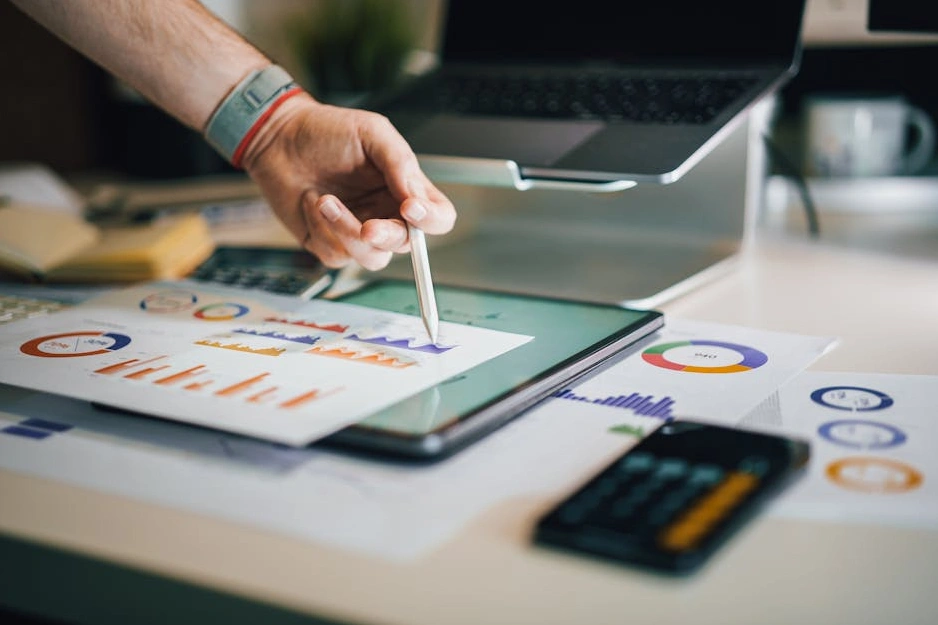 Tým analytiků diskutuje nad grafy růstu na digitální obrazovce.